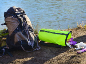 Lifestyle image of a waterproof bag sitting by a body of water